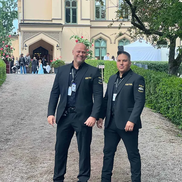 To vektere ved en herskapelig bygning med gjester