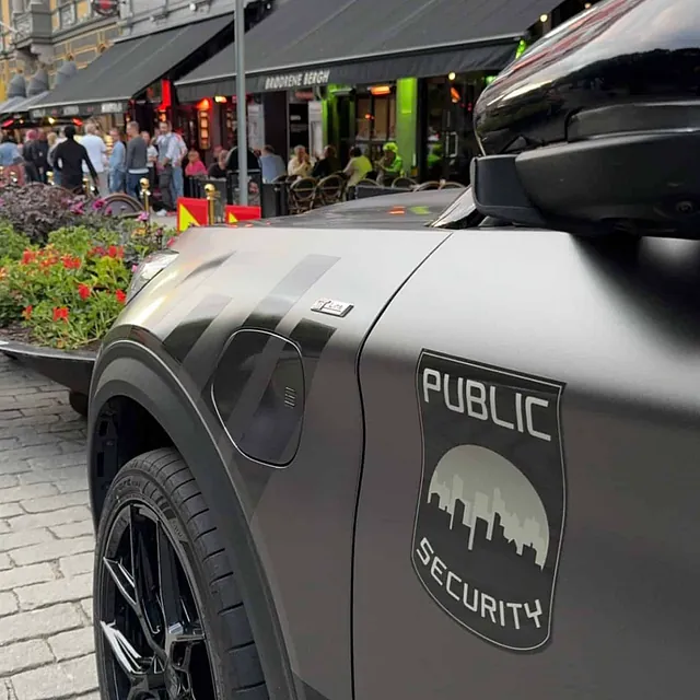 En sikkerhetsbil parkert ved utested i bygate