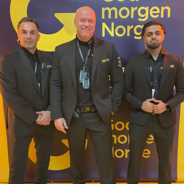 Tre vektere poserer foran God Morgen Norge-bakgrunn